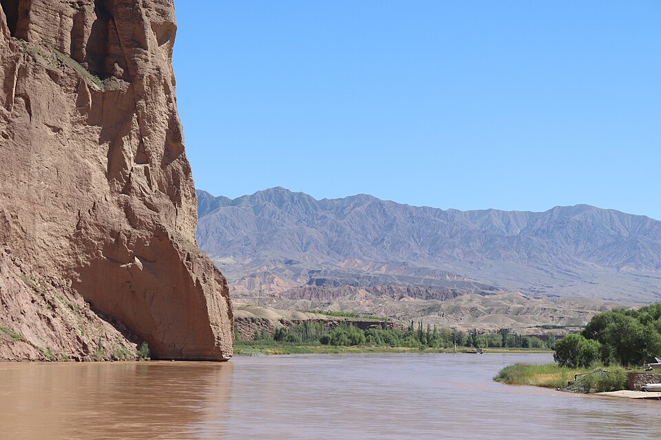 The Yellow River curving below steep red cliffs in the Jingtai Stone Forest
