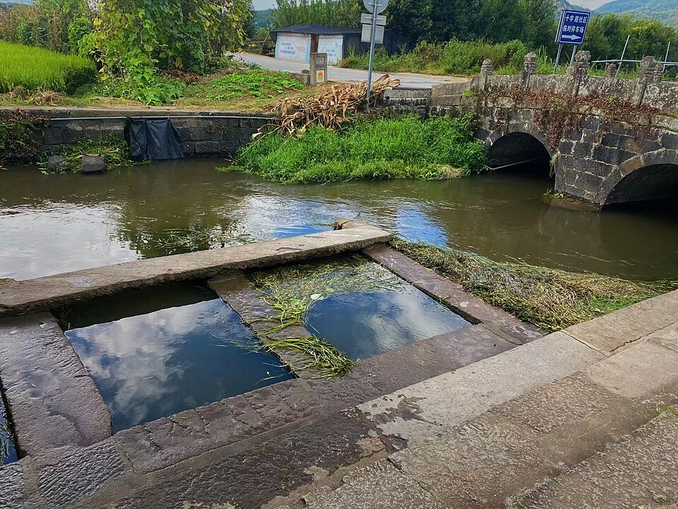 Stone bridge over a stream with willows at the foot of Heshun town