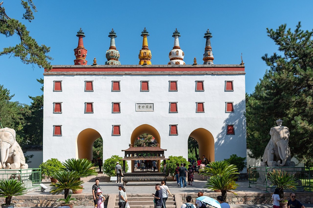 The white Five Pagoda Gate with five coloured stupas on its roof