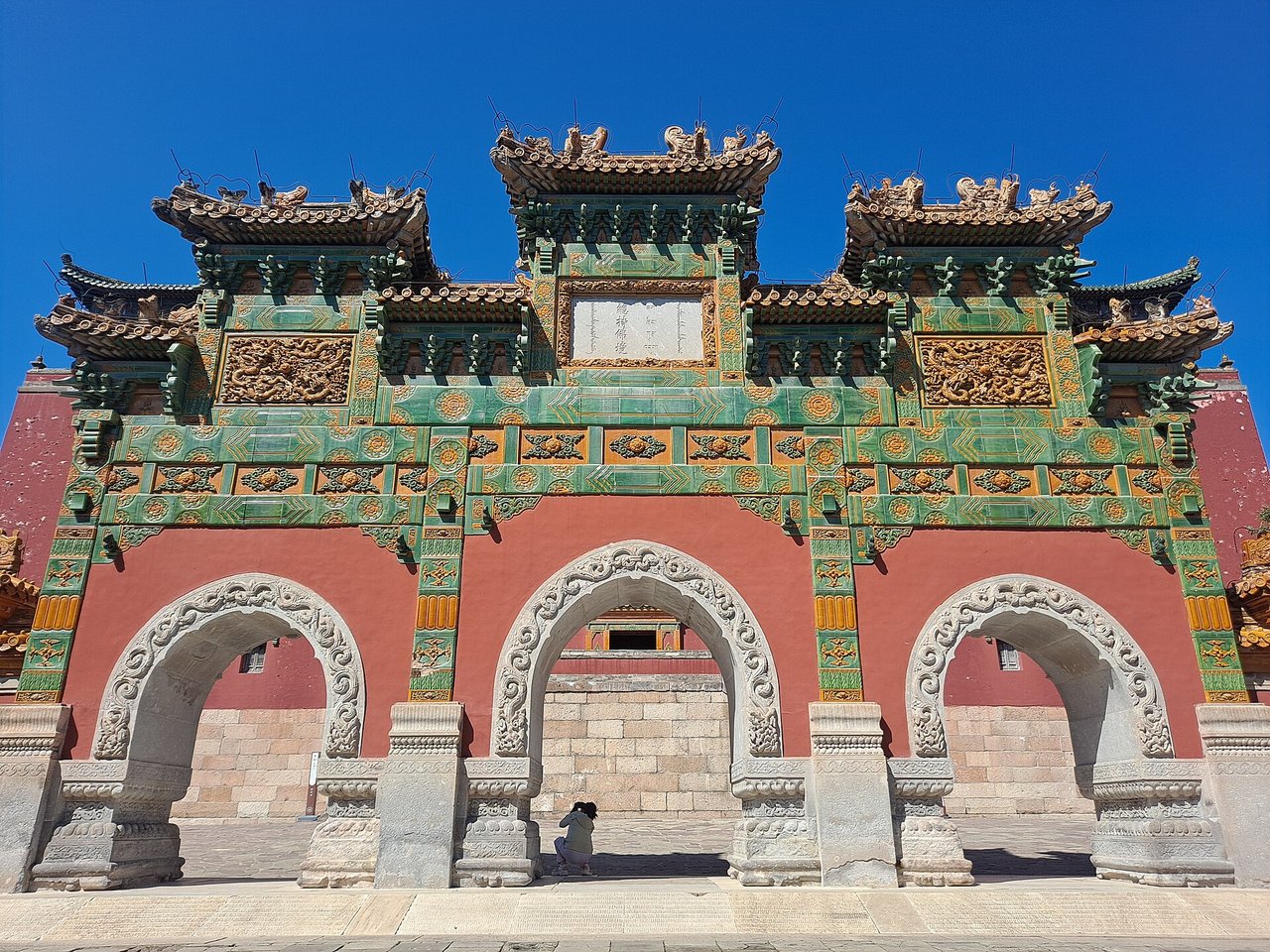 The green and yellow glazed archway of Xumi Fushou Temple with three arched passages