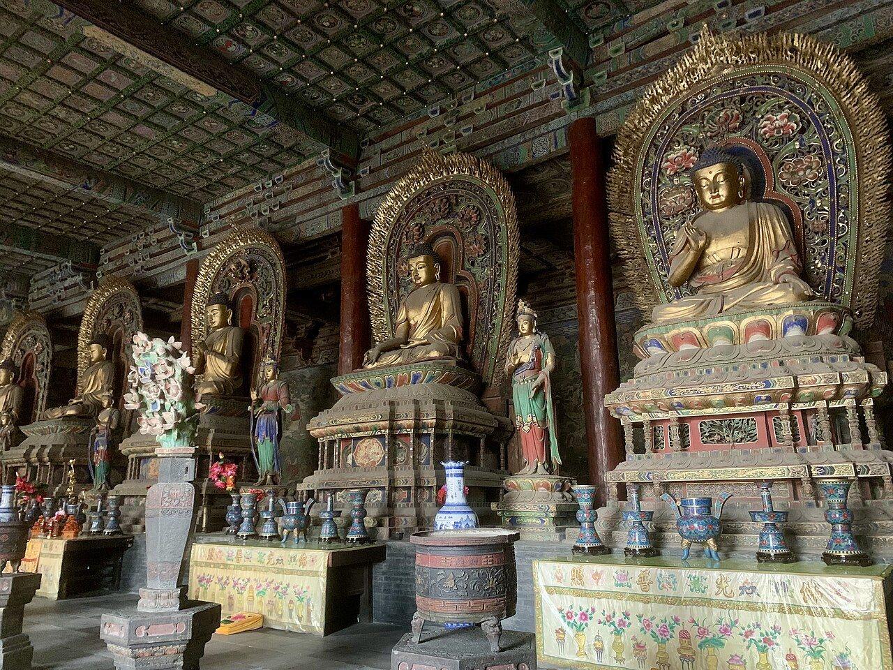 Gilded seated Buddhas on the altar inside the main hall of Huayan Temple