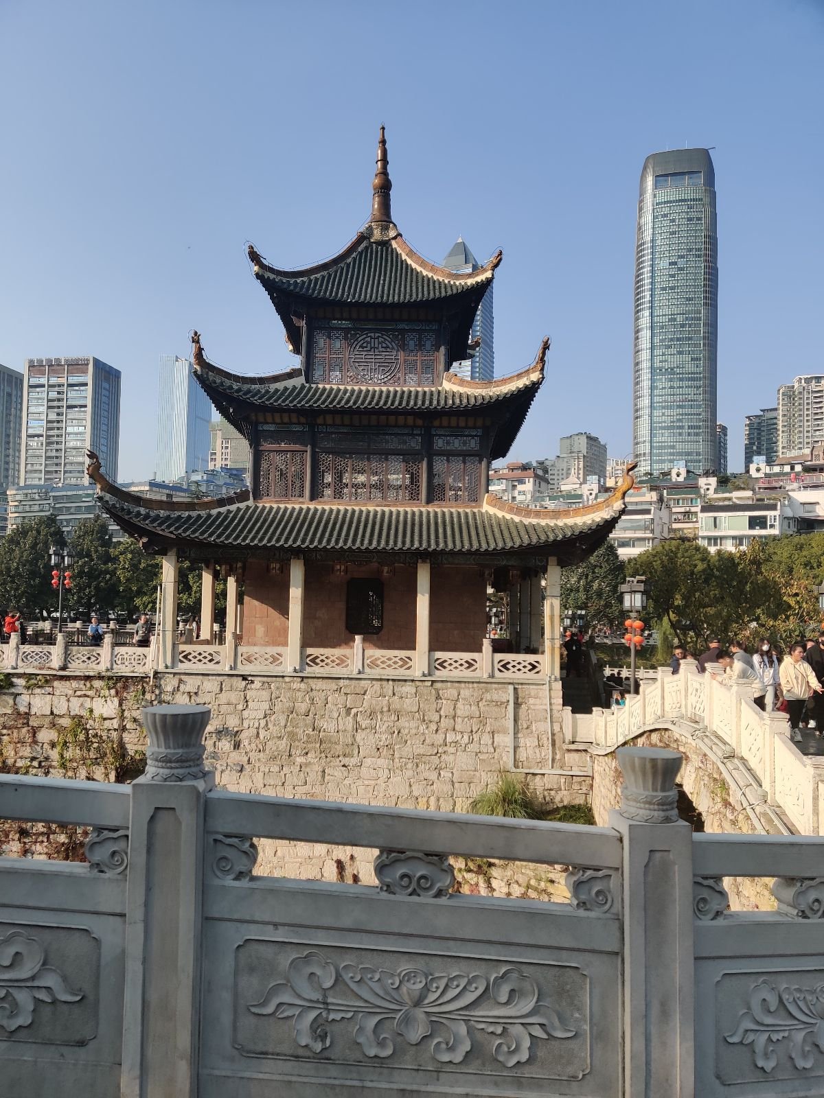 three-storey Jiaxiu Tower with a modern skyscraper behind it