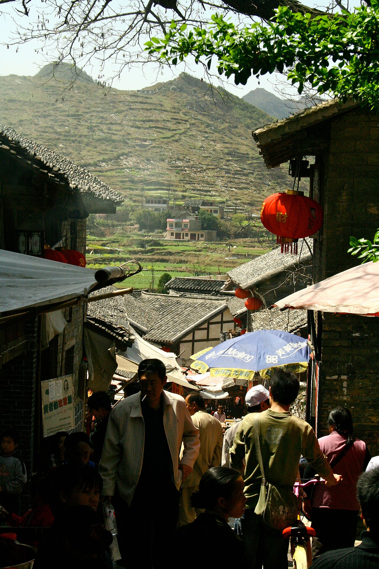 crowded stone lane in Qingyan Ancient Town with karst hills behind