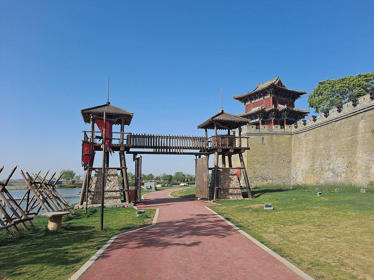 Restored wall and watchtowers beside the moat path at Guangfu