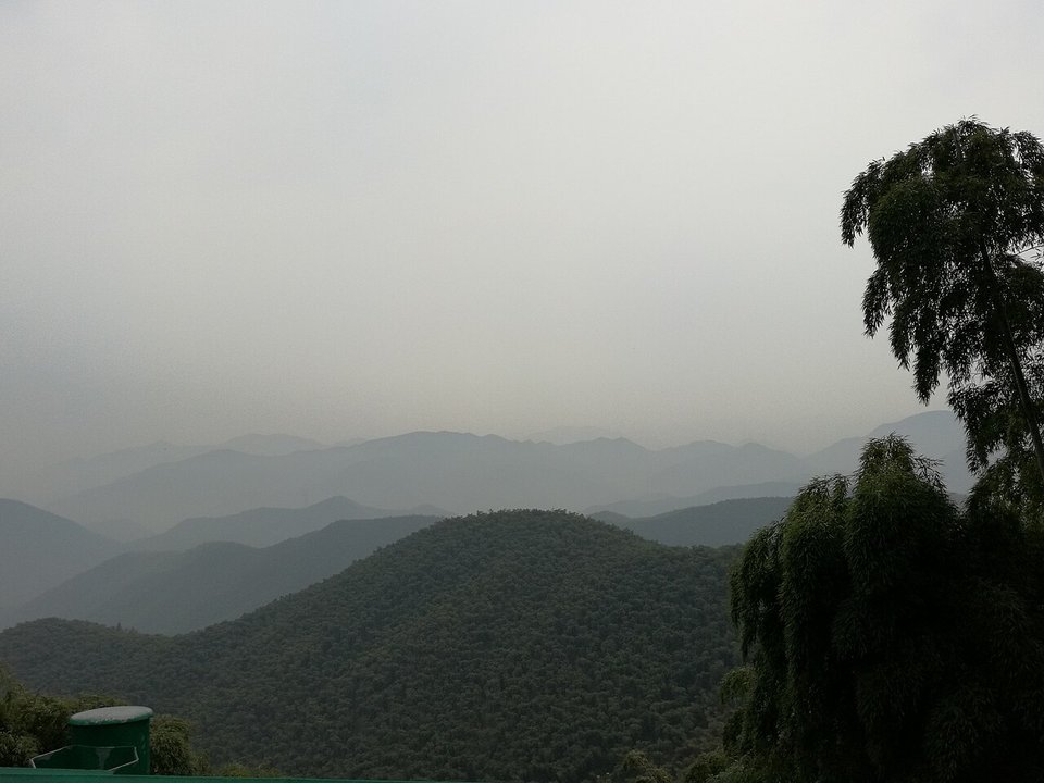 View from Moganshan across layers of forested hills under a grey sky