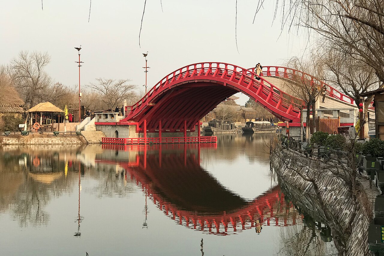 red arched Rainbow Bridge reflected in the water at Millennium City Park