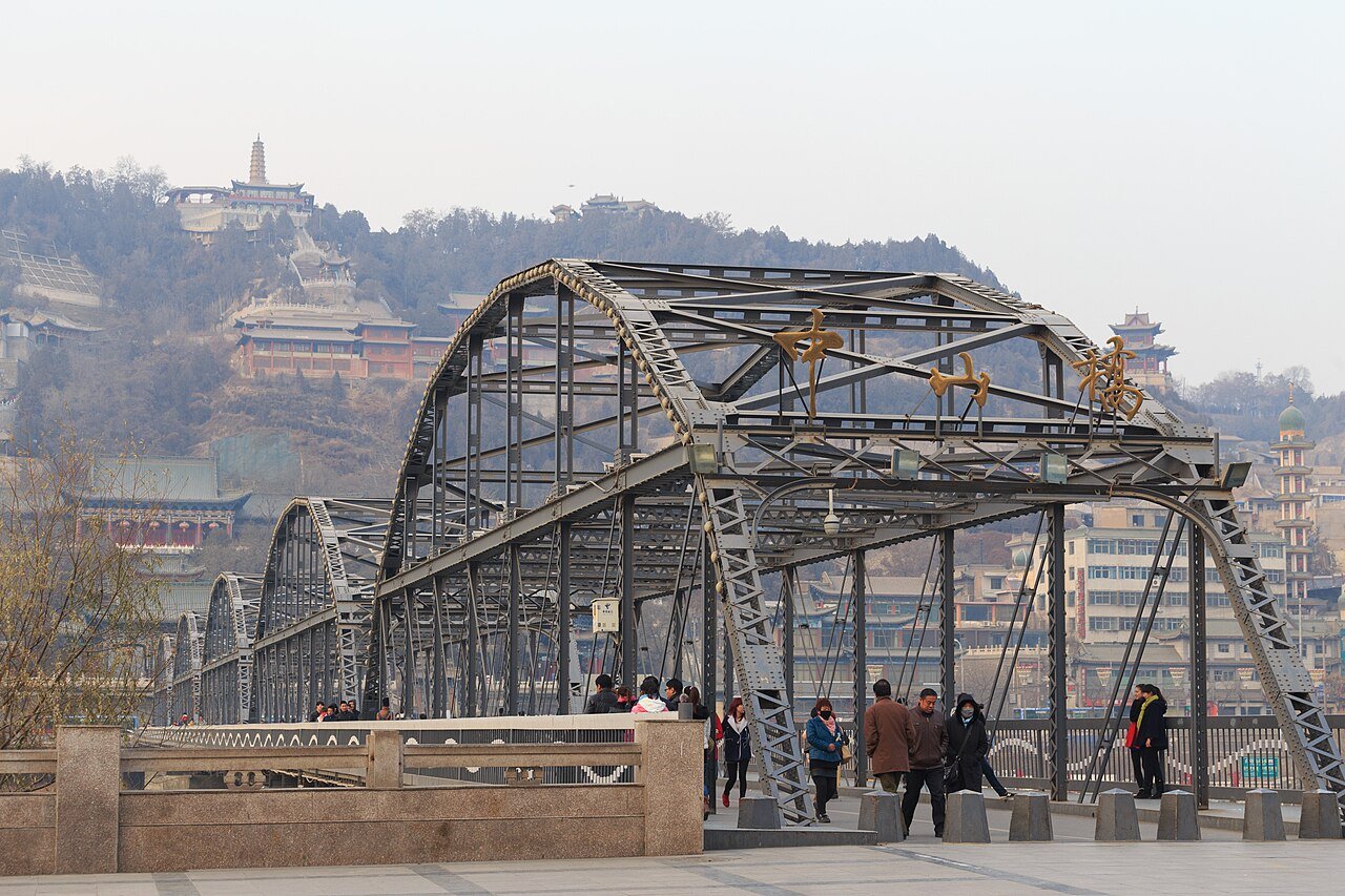 pedestrians at the southern end of Zhongshan Bridge with White Pagoda Hill and its pagoda behind