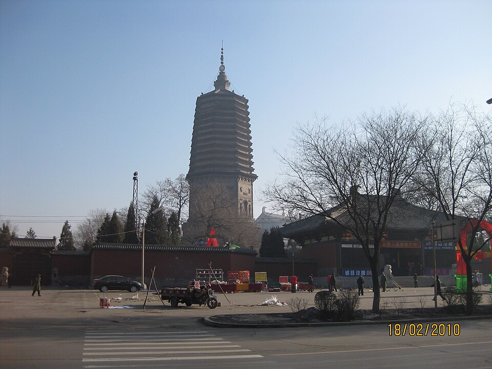 White Pagoda seen above trees and rooftops of Liaoyang
