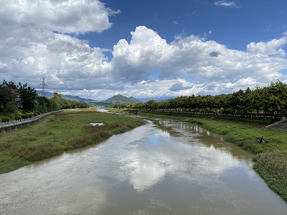 The Mengmeng River winding through a green valley in Shuangjiang, Lincang