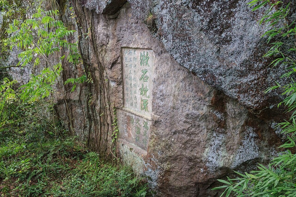 Carved inscription in red characters set into a rock face at Niweng Cave