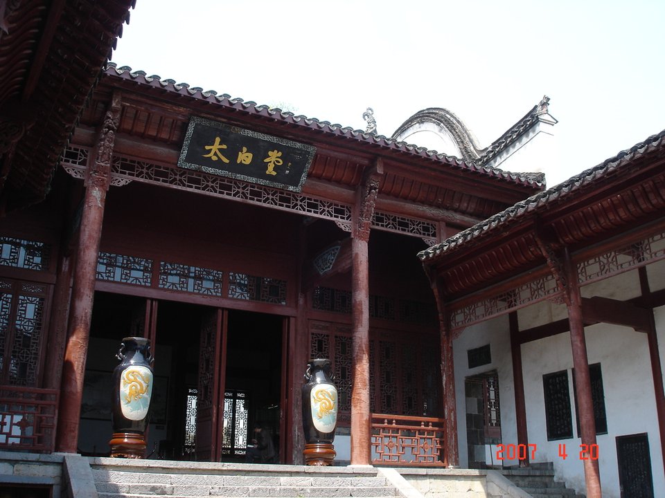 Red pillared hall with a name board and large vases at the Taibai complex at Caishi