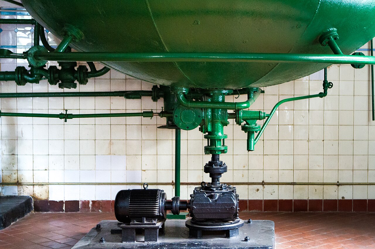 Green-painted historic brewing tank and pipework in the Tsingtao Beer Museum