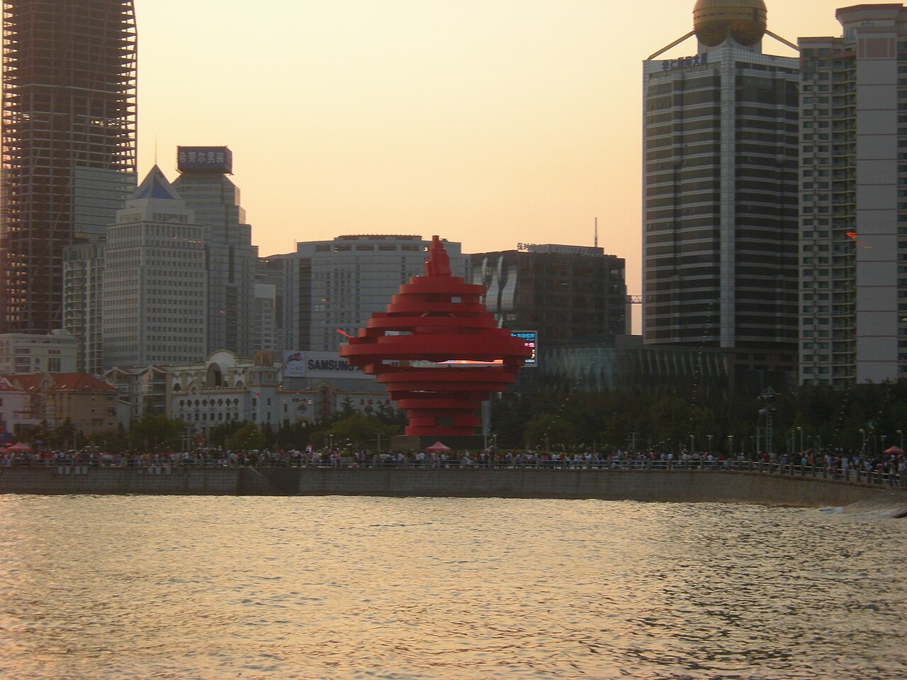 Close view of the red spiral Wind of May sculpture against a blue sky