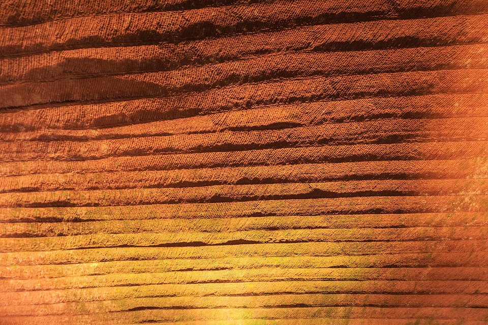 Close view of a grotto wall covered in parallel bands of diagonal chisel marks