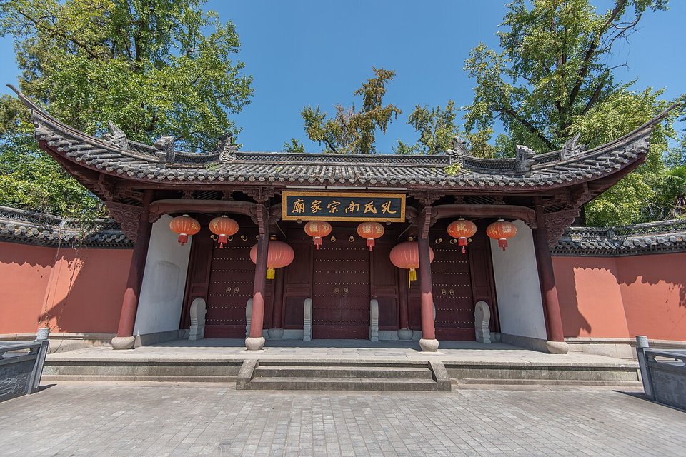 Red walled entrance gate of the Southern Confucius Family Temple under a blue sky