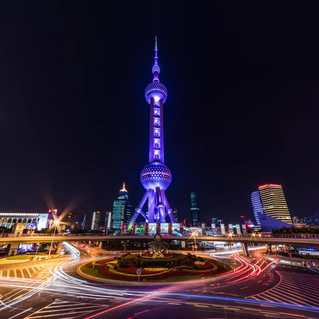 The Oriental Pearl Tower lit at night above Lujiazui traffic
