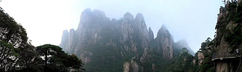 Panorama of Mount Sanqing peaks rising above a layer of cloud