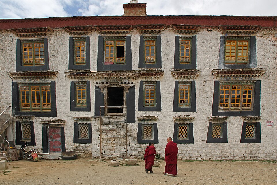 The gold-roofed central hall of Samye Monastery with whitewashed buildings around it
