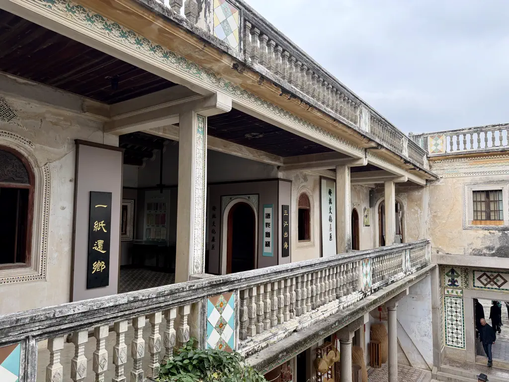 A balcony view over carved balustrades and calligraphy plaques