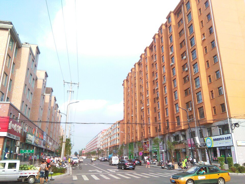 Shop-lined street with apartment blocks in Wangkui County, Suihua