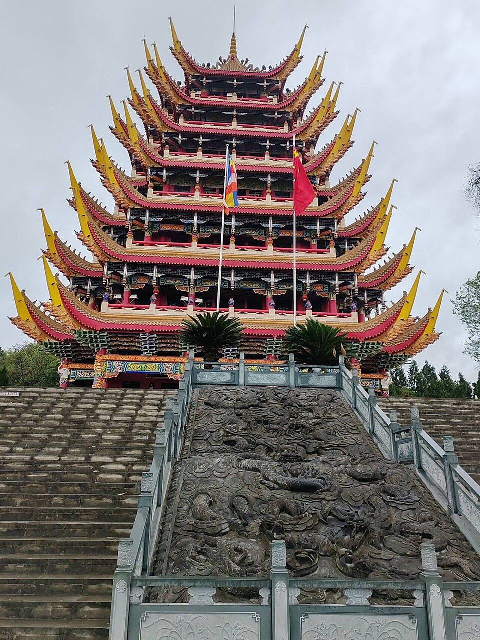 Multi-tiered red and gold pavilion above a long stone stairway at Lingquan Temple