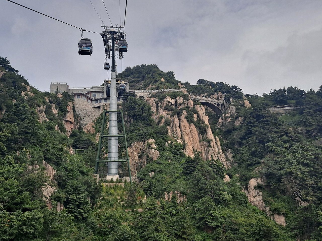 Cable car cabins and pylons on the cliffs below the summit of Mount Tai
