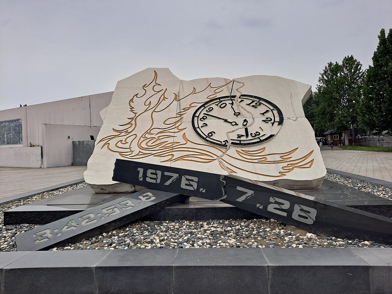Stone sculpture of a clock stopped at the time of the quake above the date 1976.7.28