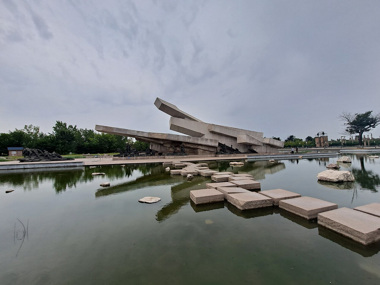 Broken concrete sculpture and stepping stones in the memorial pool at Tangshan Earthquake Ruins Memorial Park