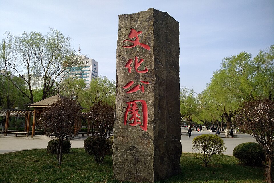Tall stone stele carved with red characters for Culture Park among spring trees in Tieling