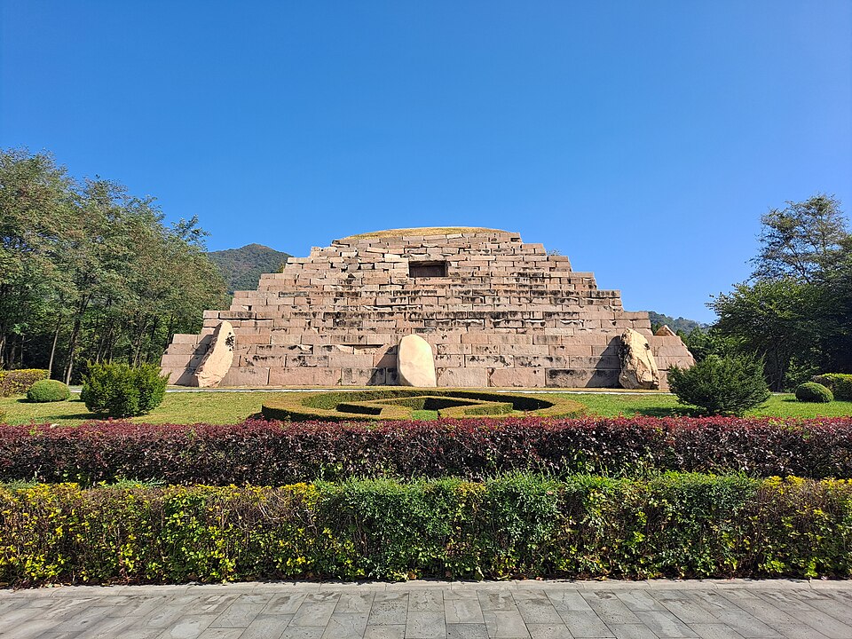 General's Tomb seen across flower beds and a paved approach in Ji'an