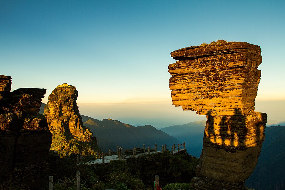 The Mushroom Stone, a top-heavy stack of rock slabs, glowing at sunset on Fanjingshan