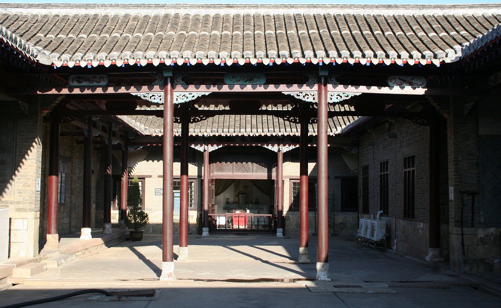 a Qing courtyard with red columns and a grey tiled roof framing an inner hall