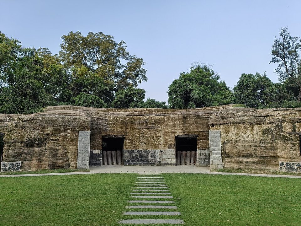 Low stone gun emplacement walls of the Jiaoshan battery among trees