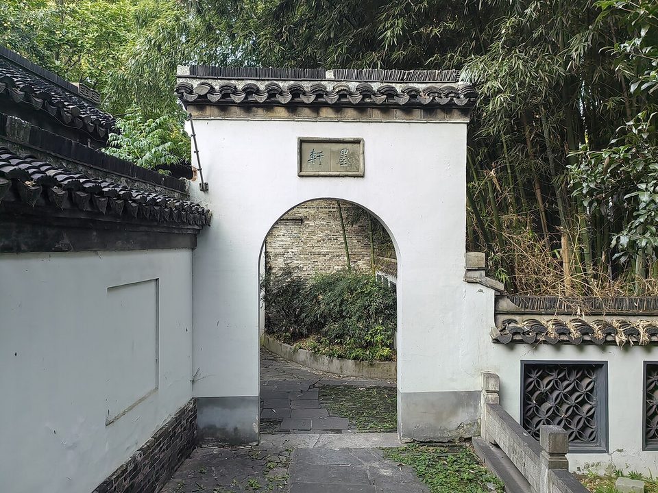 White wall with a round moon gate at the entrance to the Jiaoshan Stele Forest